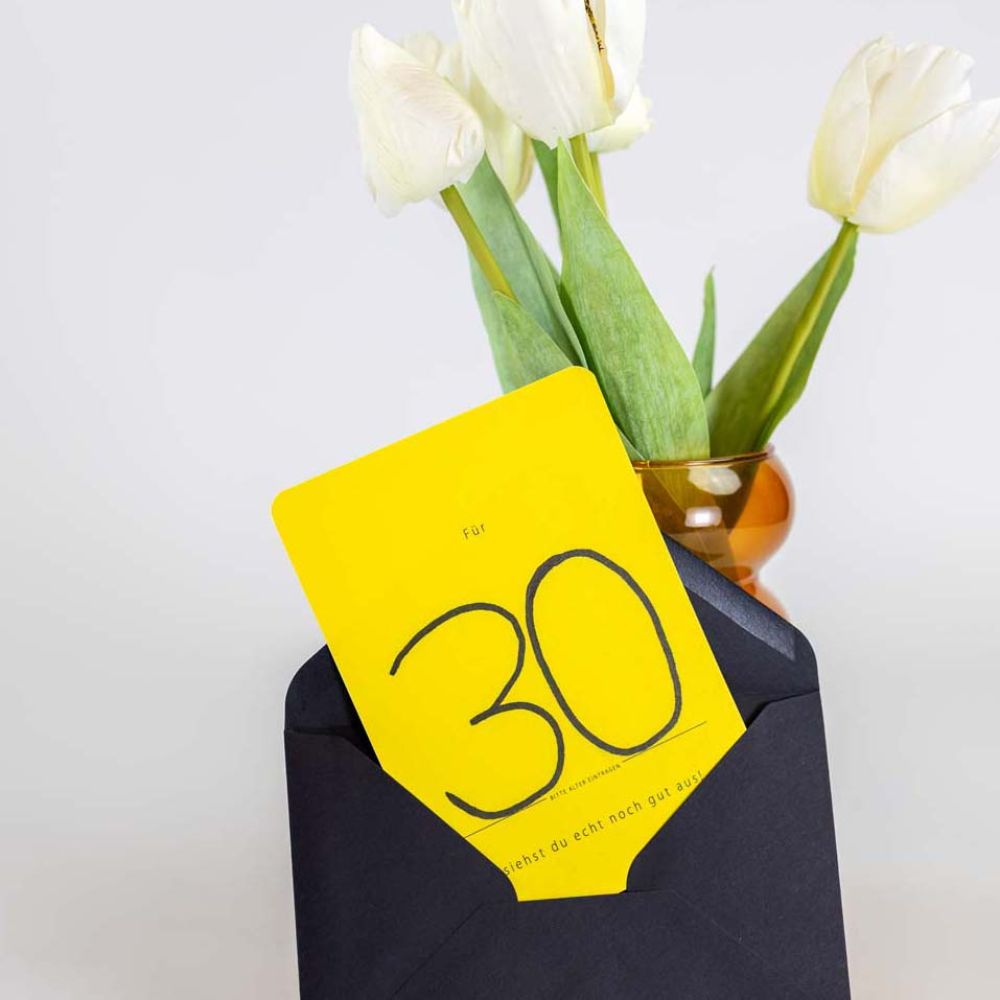 Karte im Umschlag an einer Vase angelehnt